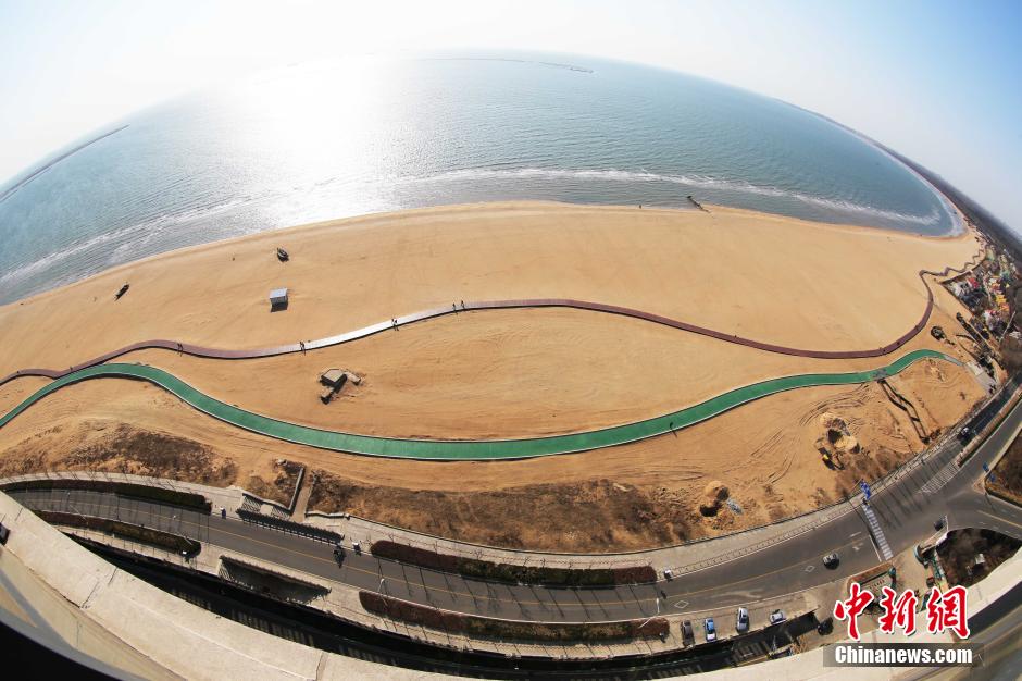 3月13日，秦皇島萬米臨海沙灘木棧道。據(jù)了解，該木棧道全長約4200米，與北戴河區(qū)原有的7500米木棧道對接后全線總長度1.17萬米，整個木棧道東起秦皇島體育基地游船碼頭，西至北戴河濕地公園，呈波浪形蜿蜒10.4公里海岸線。 中新社發(fā) 曹建雄 攝 CNSPHOTO